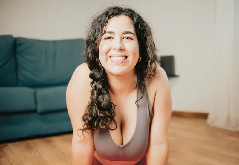 Mulher em roupa de treino, sorrindo, ilustrando conteúdo sobre preservar a massa muscular no tratamento com as canetas.