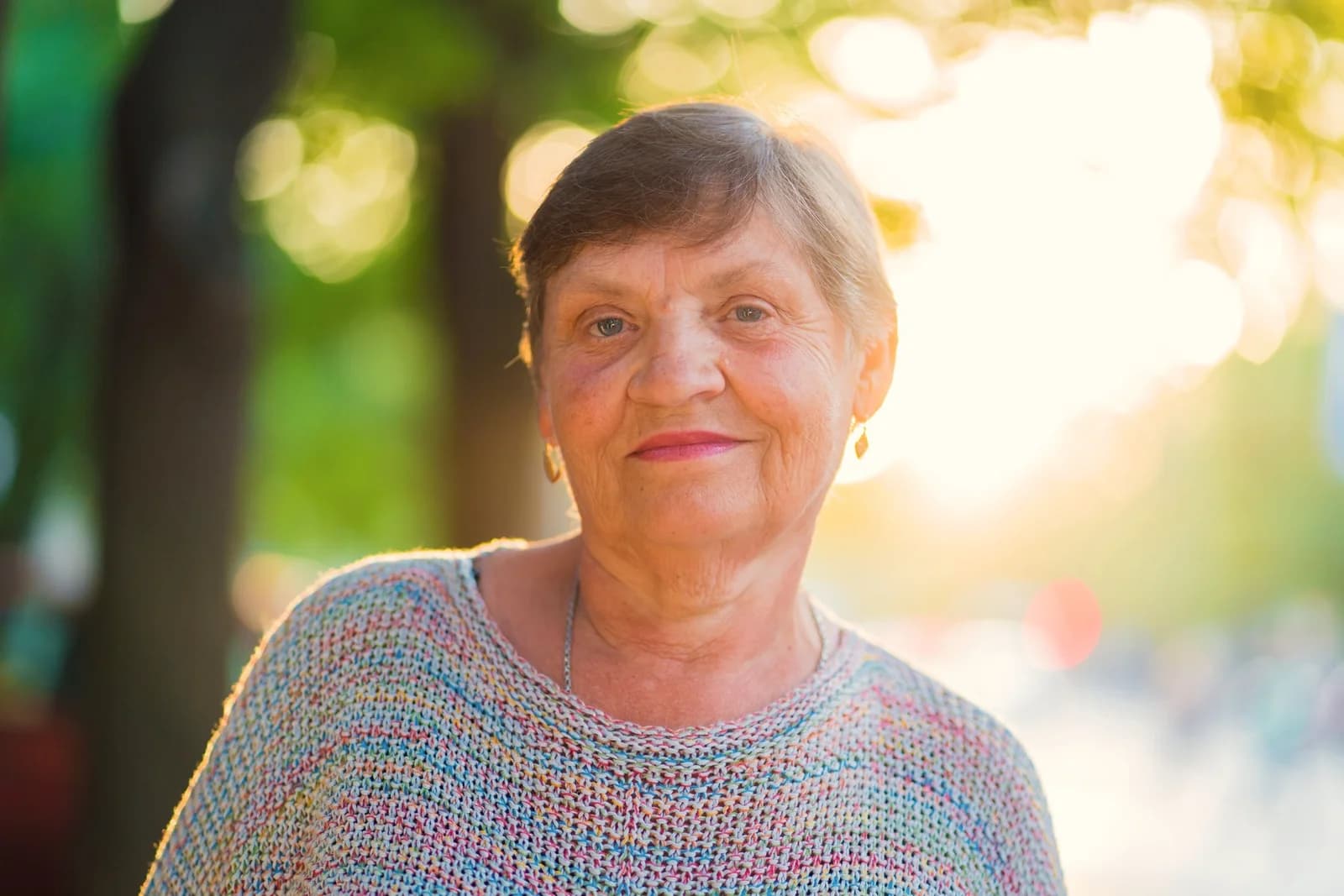 Mulher madura sorrindo ao ar livre, ilustrando conteúdo sobre a menopausa como fase natural que merece cuidado.