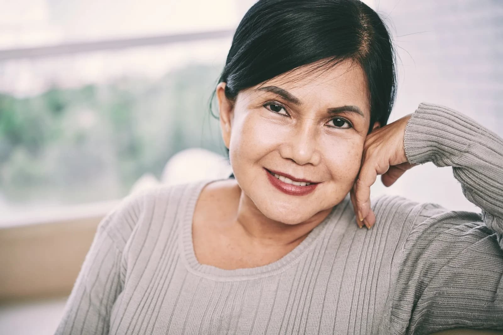 Mulher madura com expressão serena em luz natural, ilustrando conteúdo sobre reposição hormonal na menopausa.