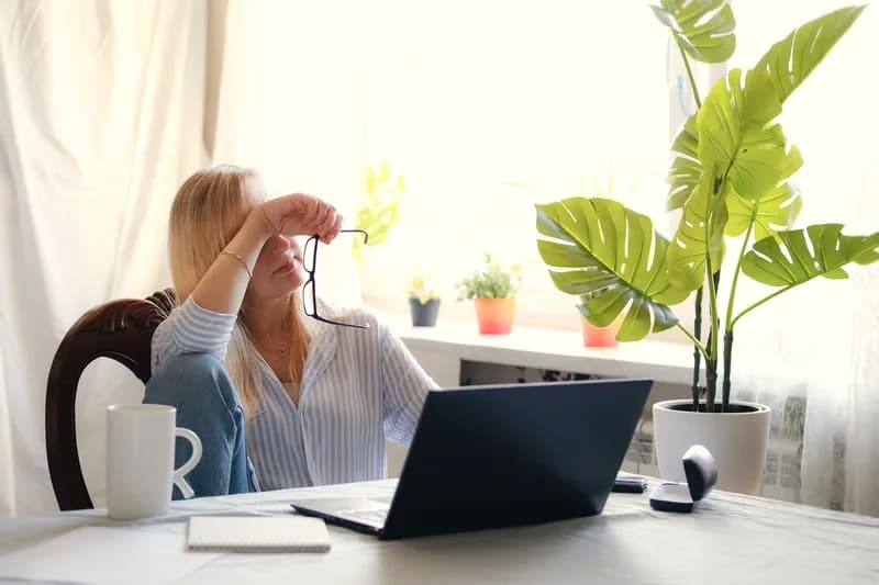 Mulher fazendo uma pausa do trabalho em casa, ilustrando conteúdo sobre exaustão e não preguiça.