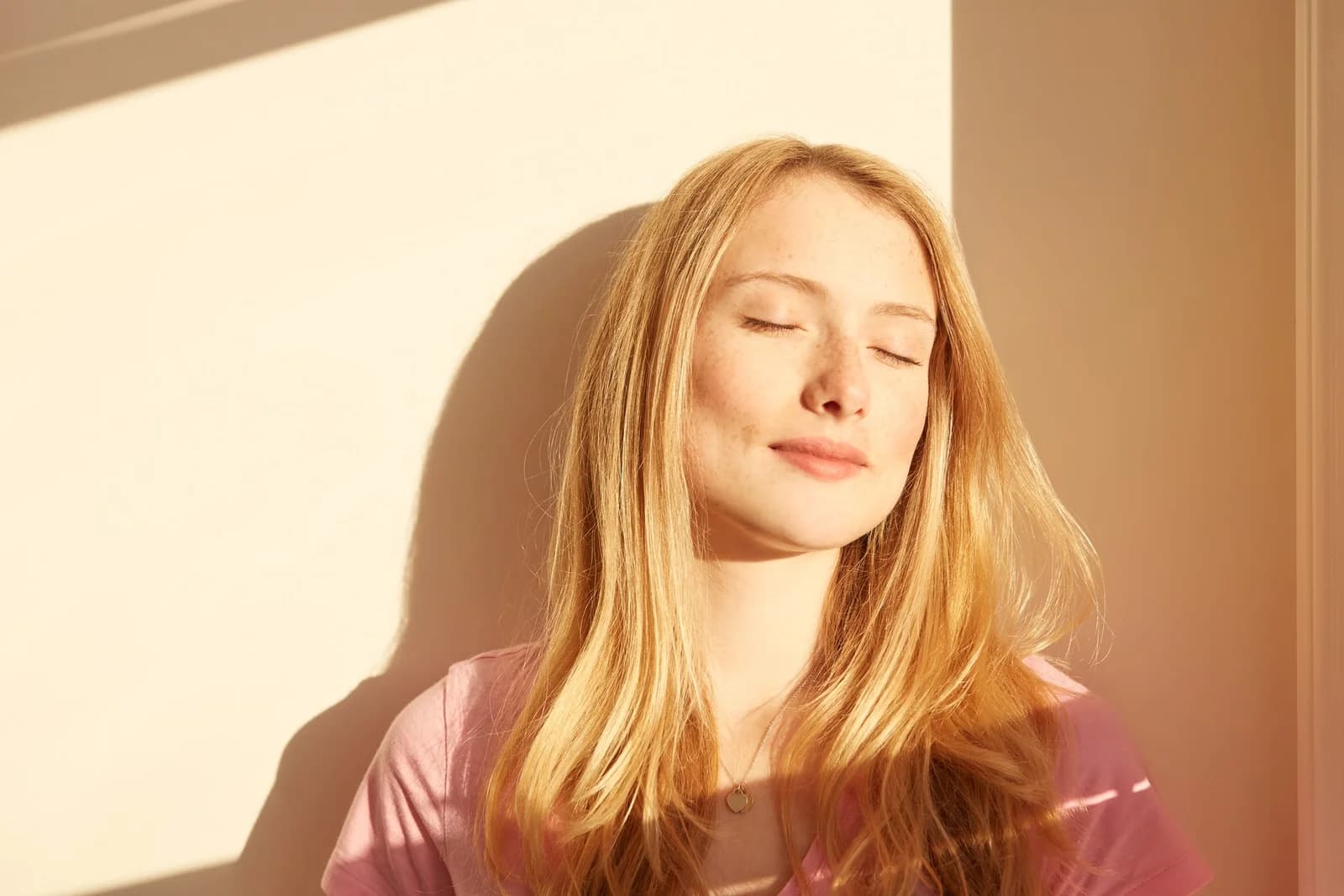 Mulher relaxada na luz do sol, ilustrando conteúdo sobre a barriga de cortisol.