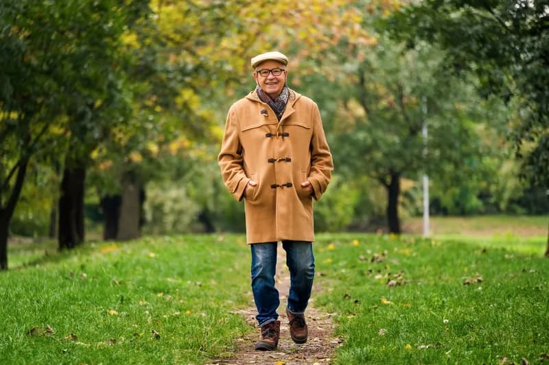 Homem caminhando em um parque no outono, ilustrando conteúdo sobre como emagrecer aumenta a testosterona.