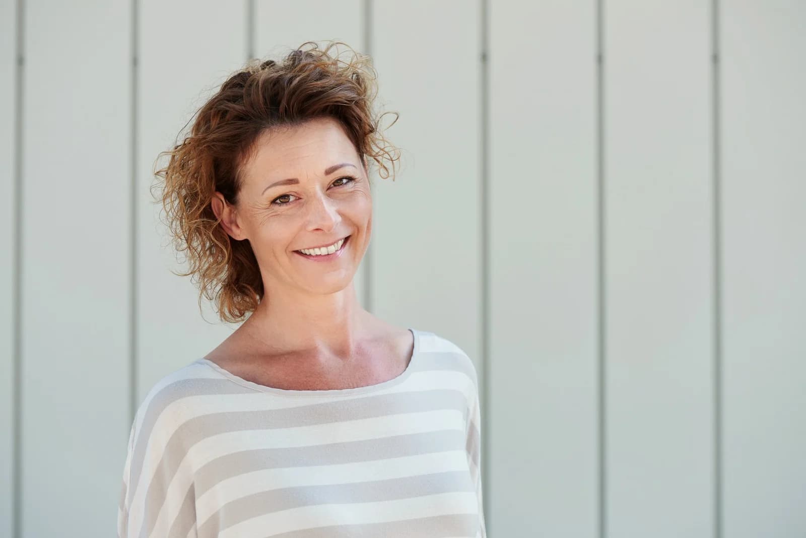 Mulher sorrindo ao ar livre, ilustrando conteúdo que diferencia SOP de hipotireoidismo.